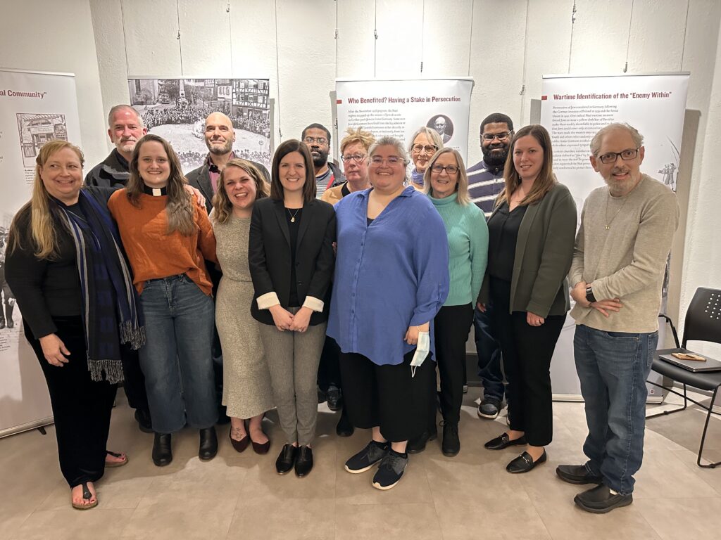 Holocaust Education event. Group of people stand in front of poster displays.