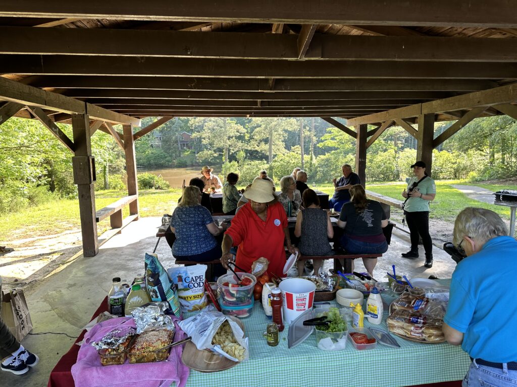 Group eating under covered picnic tables at an Assembly Meeting.