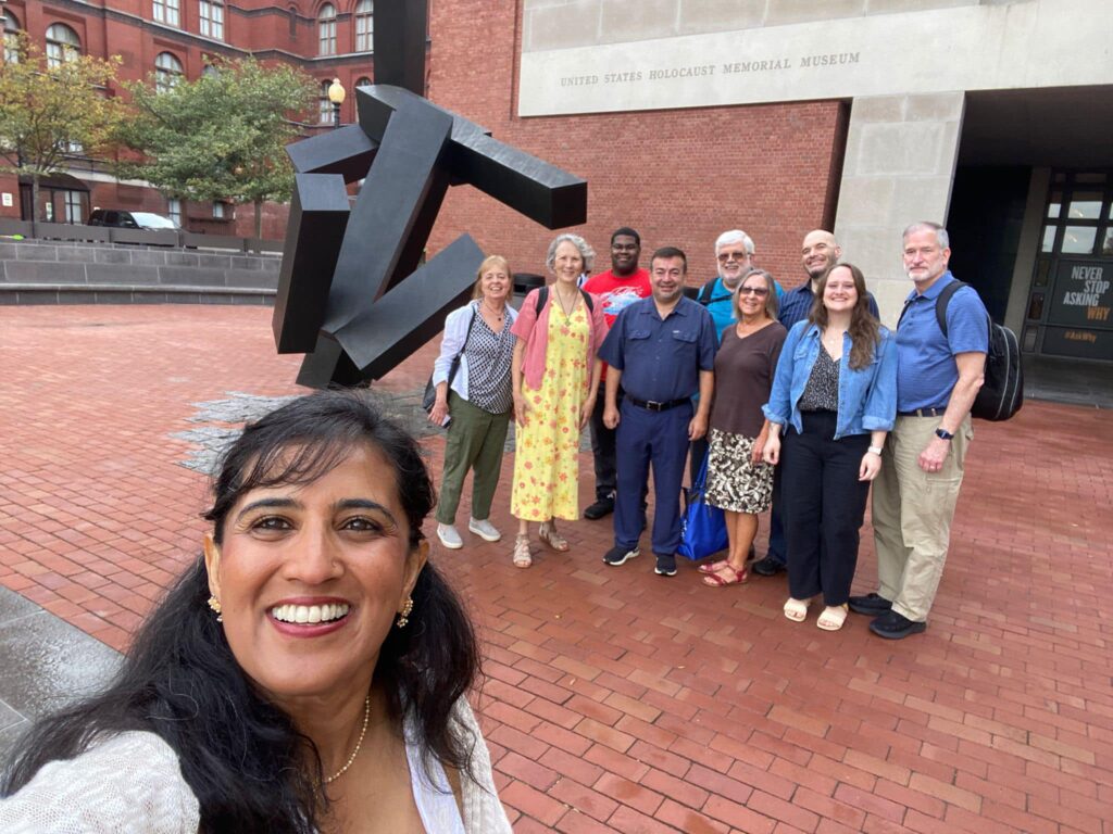 USHMM Trip to DC to learn about Anti Religious Hate. Group photo in front of sculpture. Person stands in front to take selfie.